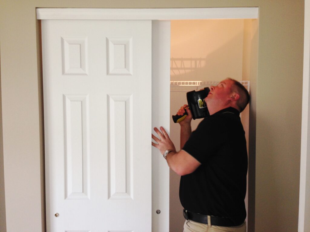 Dan Powell inspecting a closet during a home watch visit in Rochester, NY.