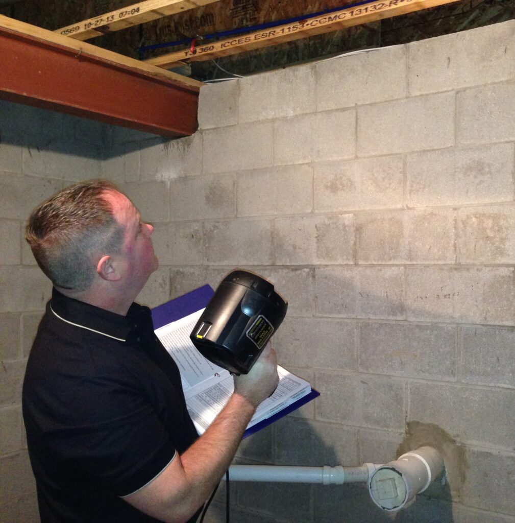 Dan Powell inspects a basement during a home watch visit in Rochester, NY.