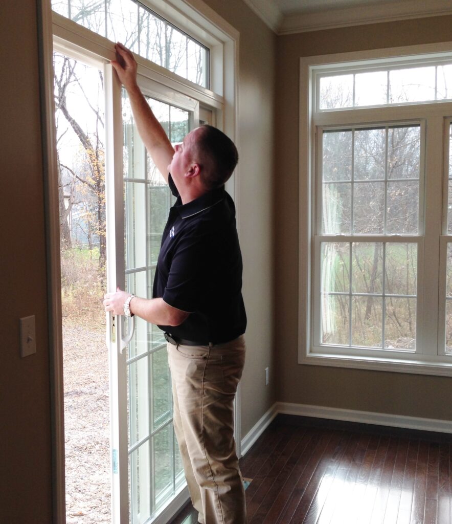 Dan Powell inspects sliding doors during a home watch visit in Rochester, NY.